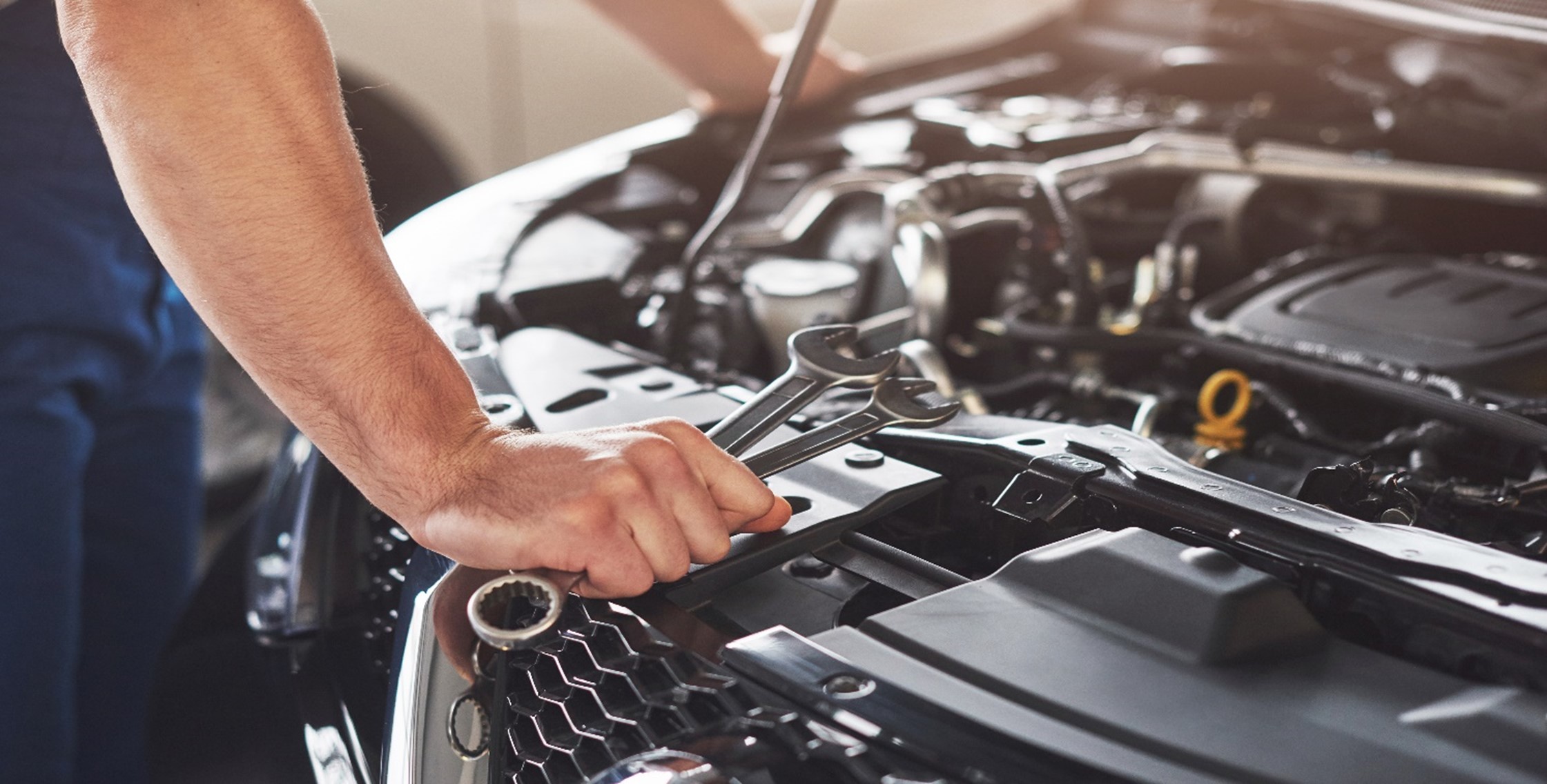 "Mechanic repairing a car engine in a garage" - Essential Vehicle Checkup Tips