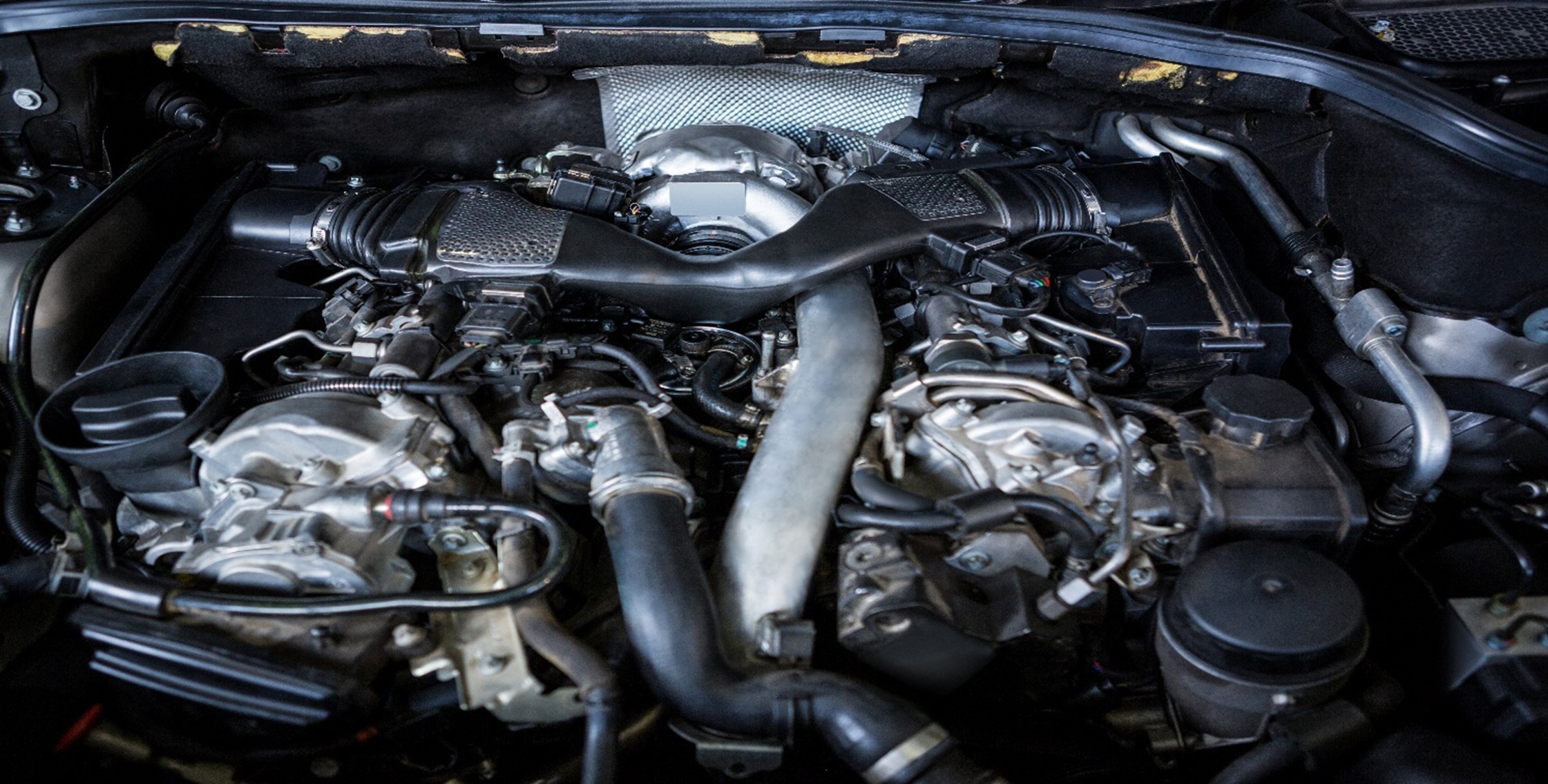 "Close-up of a car engine with intricate components" Essential Vehicle Checkup Tips