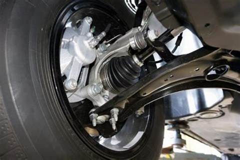 Car control arms shown with suspension parts in a workshop