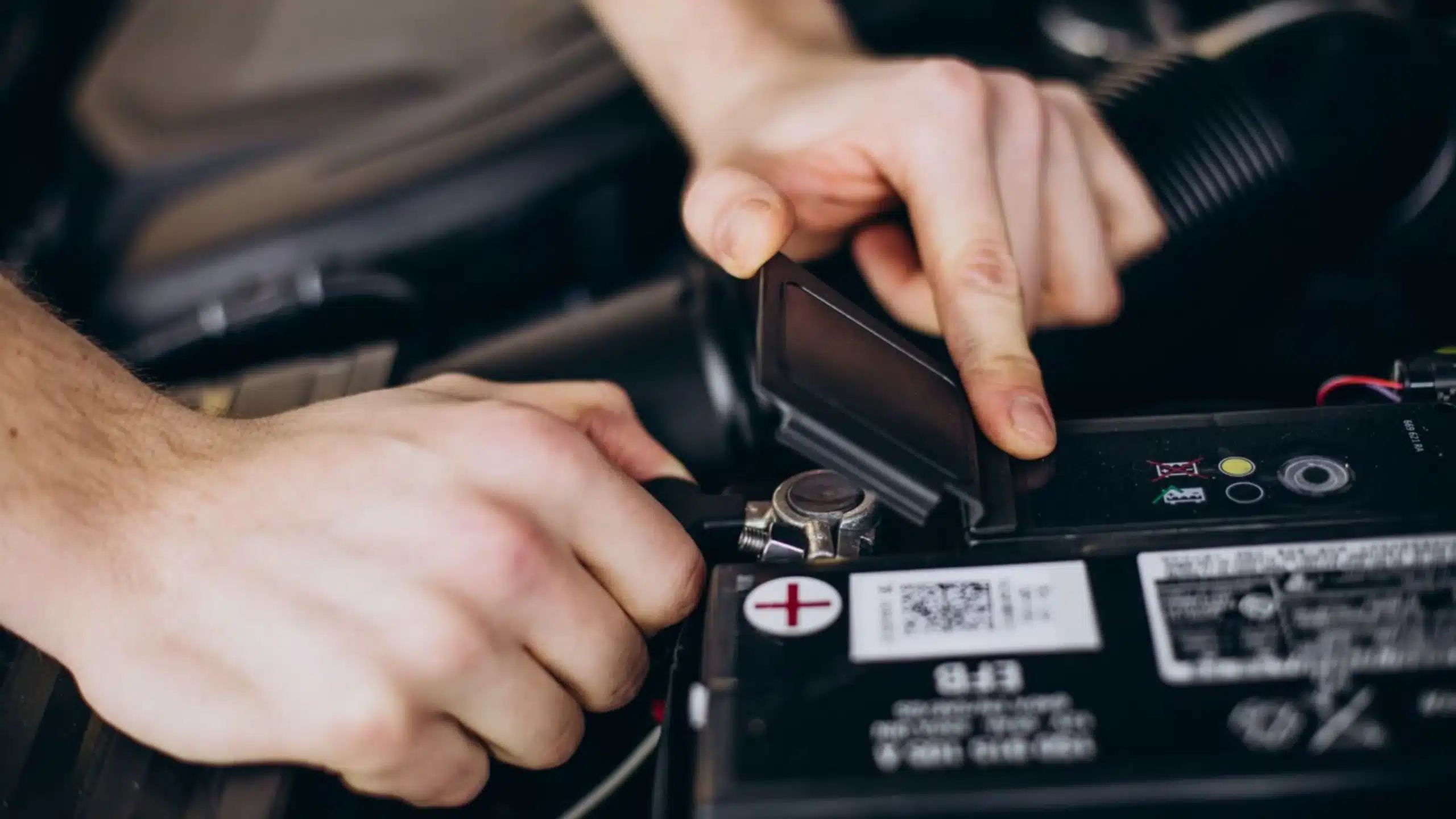 Mechanic inspecting a car battery terminal for signs of corrosion and wear.